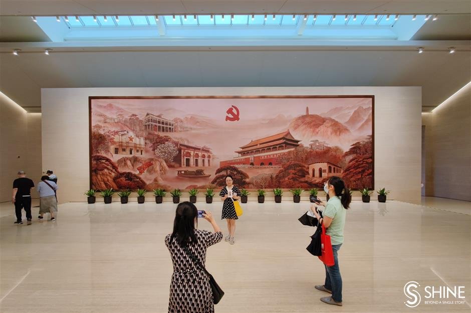 I visitatori scattano fotografie su una mostra multimediale al memoriale.